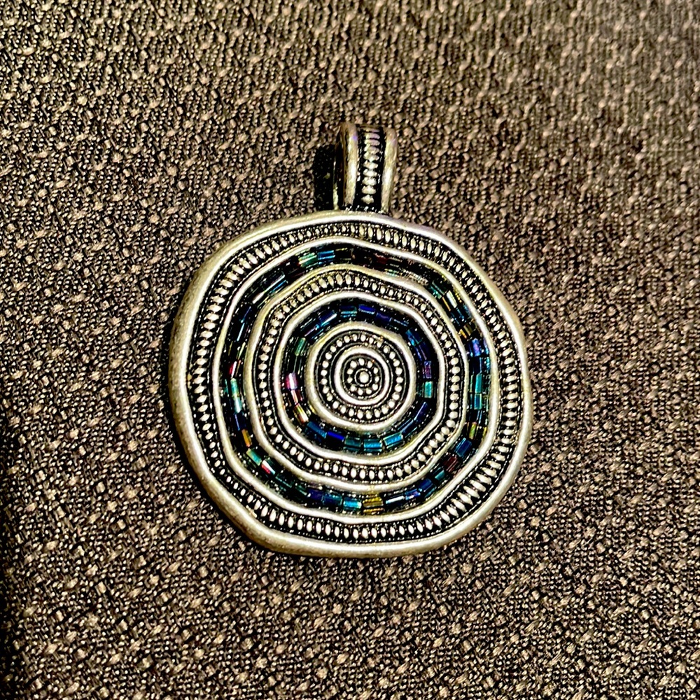I used to wear this on a leather string or a piece of silk string.
